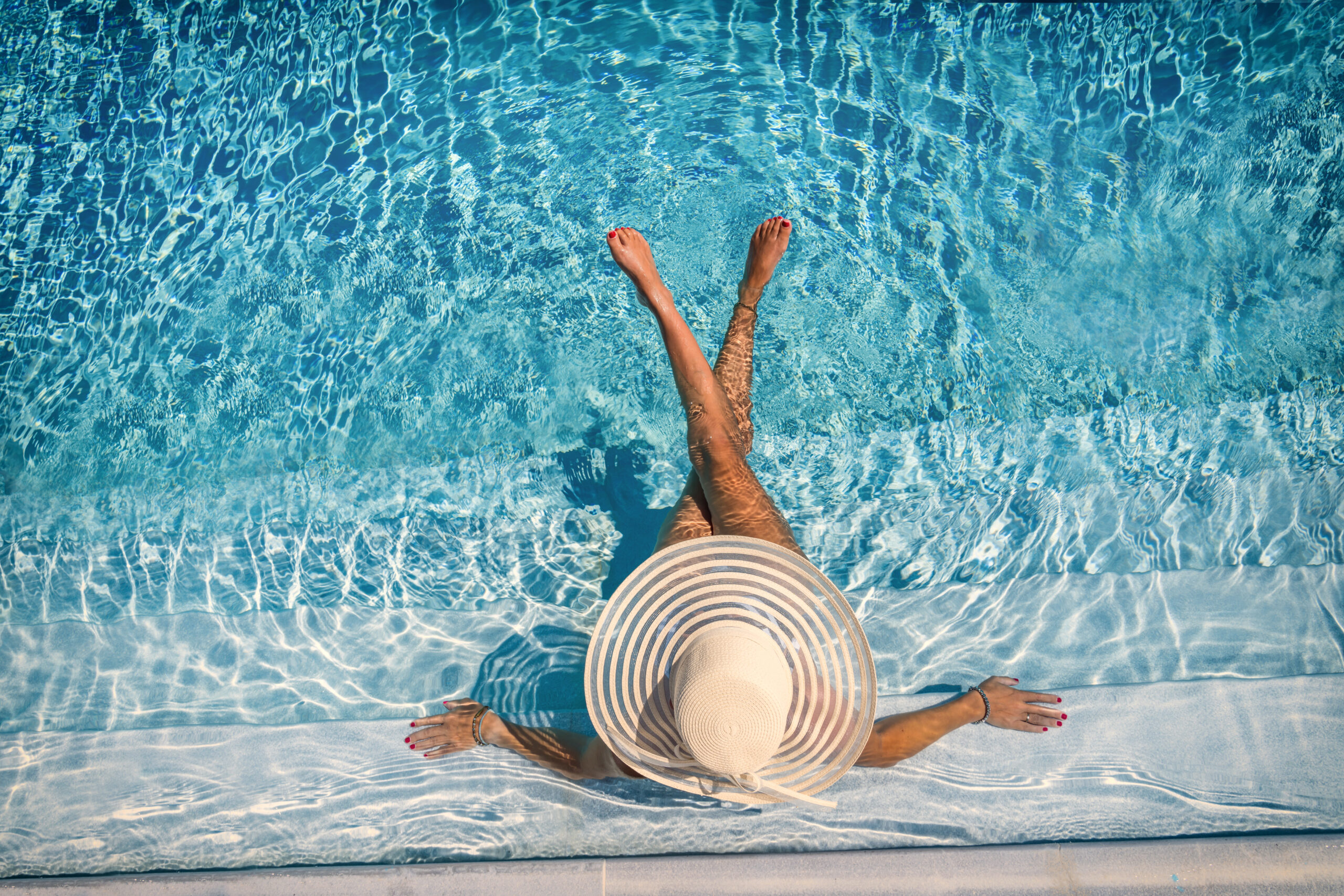 woman sitting on the stairs of a luxury five stars  spa resort  swimming pool.