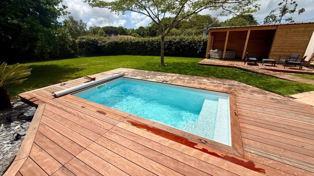 mini piscine bleue turquoise avec margelles posées