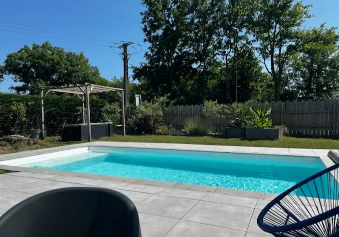 Piscine coque à l'eau claire et turquoise en plein soleil d'été en Loire-Atlantique